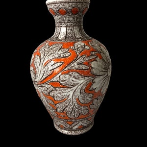 May include: A white ceramic vase with an orange floral design. The vase has a wide base and a narrow neck.