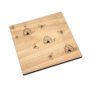 May include: Wooden beehive ruler with three beehives and bees, measuring 1 inch, 2 inches, and 3 inches.
