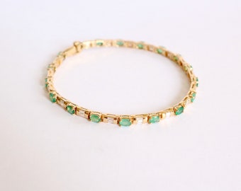 Line bracelet in 18 kt yellow gold setting 18 emeralds and diamonds