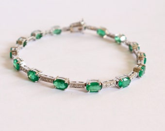 Line bracelet in 18 kt white gold setting 15 emeralds and 45 diamonds