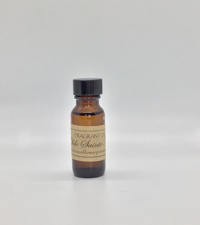 Puede incluir: Una peque&ntilde;a botella de vidrio marr&oacute;n con una tapa negra. La botella est&aacute; etiquetada "FRAGRANT OIL  Vde Sainte ... densunflowerprimitiv"