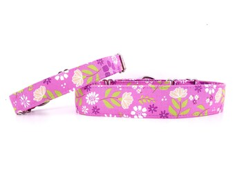 May include: Two pink dog collars with a floral pattern. The collars are made of fabric and have silver hardware.