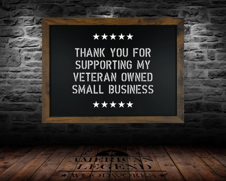 May include: A black chalkboard with a wooden frame hangs on a brick wall. The chalkboard has white text that reads "Thank you for supporting my veteran owned small business." There are five stars above and below the text.