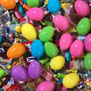 May include: A large assortment of colorful plastic Easter eggs filled with various candies and treats. The eggs are in a variety of colors, including pink, yellow, green, blue, and purple. The candies include chocolate, gummies, and hard candies.