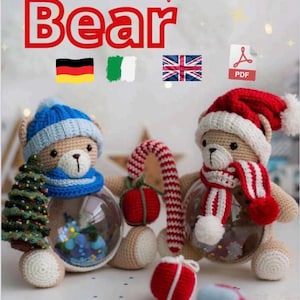 Può includere: Due orsacchiotti di peluche all'uncinetto vestiti con abiti natalizi. Un orso indossa un cappello e una sciarpa blu e tiene un piccolo albero di Natale. L'altro orso indossa un cappello da Babbo Natale rosso e una sciarpa e tiene una canna di zucchero. Entrambi gli orsi tengono un ornamento di palla di vetro trasparente.