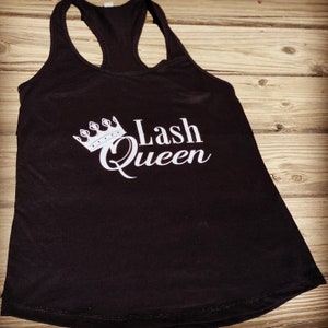 May include: Black tank top with a white crown and the text "Lash Queen" printed on the front.
