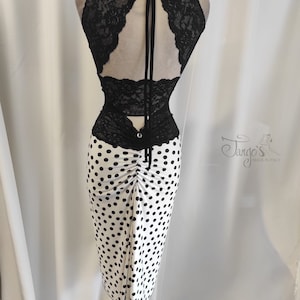 Peut inclure: Un haut en dentelle noire avec un dos en forme de trou de serrure et une jupe blanche à pois noirs. La jupe est froncée à la taille et a une légère forme trapèze.