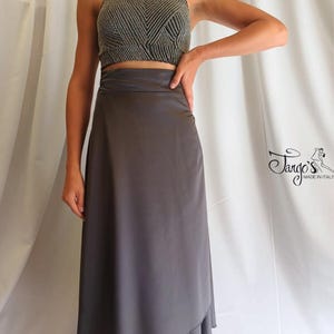 May include: A two-piece dance outfit featuring a halter top and a skirt. The top is a textured, patterned fabric in shades of gray and black. The skirt is a solid, flowing gray material. The outfit is designed for dance.