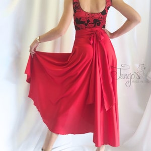 May include: A red wrap skirt with a black and red floral top. The skirt has a long, flowing design and is tied at the waist with a bow. The top is sleeveless and has a scoop neckline. The skirt is made in Italy.