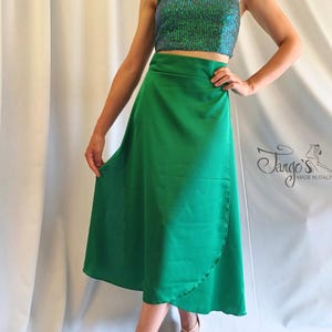 May include: A green wrap skirt and a sequined halter top. The top is a shimmering teal color, and the skirt is a solid, vibrant green. The outfit is suitable for dance or special occasions. The brand logo "Tango's Made in Italy" is visible.