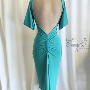 Op de afbeelding: Een turquoise, mouwloze jurk met een lage rug en een gerimpelde rok. De jurk is gemaakt van een rekbare stof en heeft een aansluitende pasvorm. De jurk is op een mannequin en wordt getoond tegen een witte achtergrond.