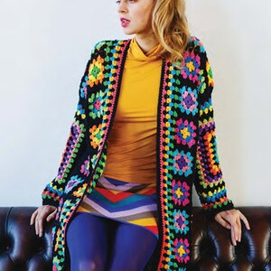 Puede incluir: Un c&aacute;rdigan de crochet negro con un patr&oacute;n geom&eacute;trico colorido. El c&aacute;rdigan est&aacute; abierto en la parte delantera y tiene mangas largas. La modelo lleva una blusa amarilla y una falda de rayas de colores.