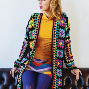 Puede incluir: Un c&aacute;rdigan de crochet negro con un patr&oacute;n geom&eacute;trico colorido. El c&aacute;rdigan est&aacute; abierto en la parte delantera y tiene mangas largas. La modelo lleva una blusa amarilla y una falda de rayas de colores.