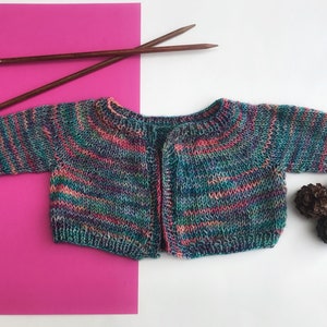 May include: A multi-colored striped knitted cardigan with a button closure. The cardigan is made with a soft yarn and has a relaxed fit.