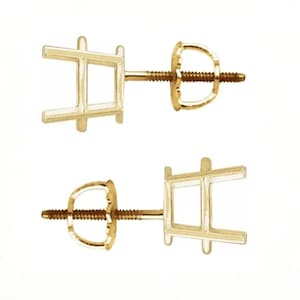May include: A pair of gold stud earring settings featuring a four-prong basket design. Each setting includes a threaded post and a matching screw-back closure, designed to hold a gemstone securely in place with a classic, functional structure.