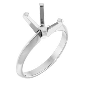 May include: A polished silver-toned metal ring setting featuring a four-prong head designed to hold a single gemstone. The band is smooth and rounded, leading up to a structured mounting that provides a secure base for a center stone to be set.