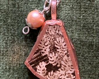 Collar colgante hecho con una pieza de cerámica de un plato de porción vintage.