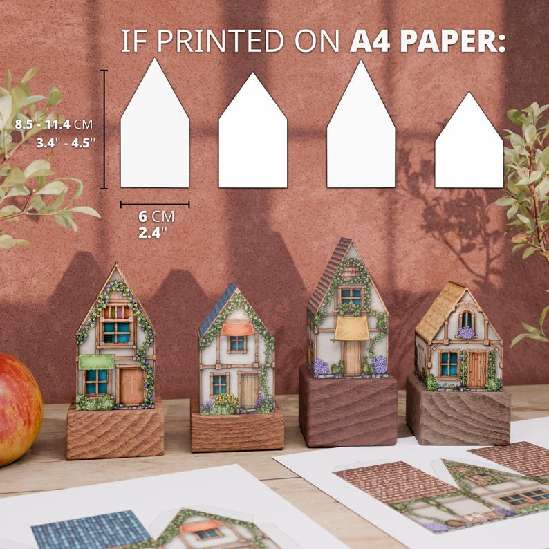 A visual guide to the size of the paper cottages. A diagram at the top explains that if printed on A4 paper, the models are 8.5 to 11.4 cm (3.4 to 4.5 inches) tall and 6 cm (2.4 inches) wide. Below the diagram, the four assembled, colorful cottage models are lined up to provide a real-world visual reference for their scale.