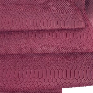 May include: Burgundy faux snakeskin fabric with a textured, embossed pattern. The fabric is folded in thirds, showing the texture from different angles.