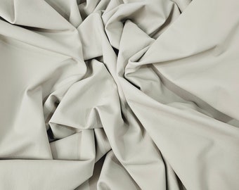 May include: A piece of off-white leather fabric, folded and crumpled, creating a soft, textured surface.