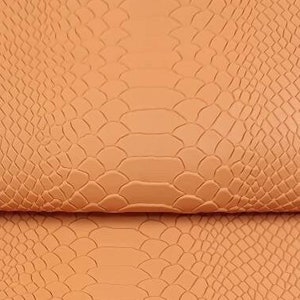 Puede incluir: Tres piezas de piel sintética naranja con textura de piel de serpiente en relieve.