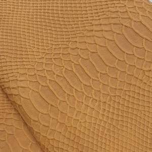 Può includere: Un pezzo di pelle marrone con un motivo goffrato a pelle di serpente.
