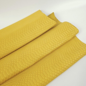 Peut inclure: Gros plan sur un tissu en similicuir jaune à motif peau de serpent.