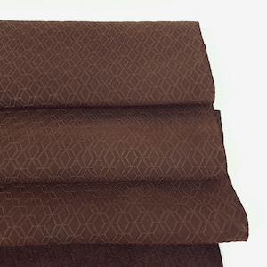 May include: Brown fabric with a geometric pattern. The fabric is folded in thirds.