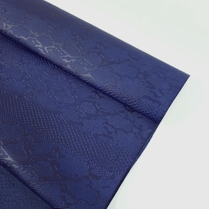 Peut inclure: Gros plan sur un tissu en similicuir bleu foncé avec un motif gaufré en peau de serpent.