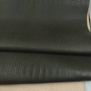 Puede incluir: Primer plano de una tela de imitación de cuero verde oscuro con un patrón en relieve de cocodrilo.