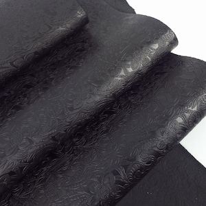 Piel negra con textura repujada, estampado floral estilo western vintage y efecto pull up.