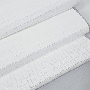 May include: Three pieces of white faux leather with a crocodile embossed pattern. The leather is folded in a stack.