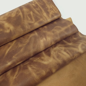 May include: Close-up of a stack of brown leather, showing the texture and grain of the material.