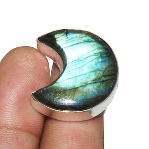 May include: A crescent moon shaped ring with a blue and green labradorite gemstone set in silver.