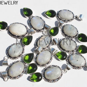 May include: A group of 10 silver pendants with oval moonstone and pear-shaped green peridot gemstones. The pendants have a decorative filigree design around the stones.