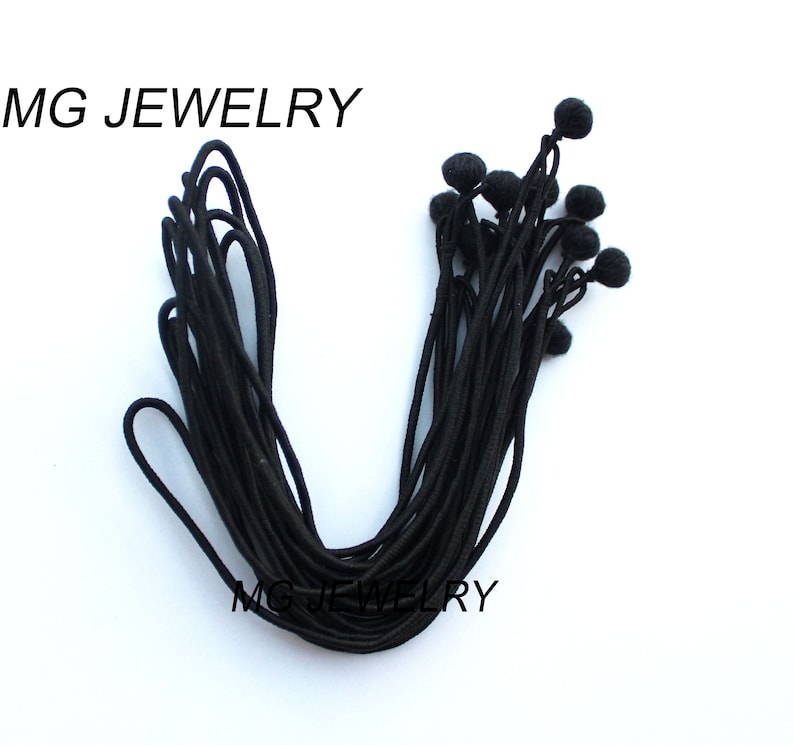 May include: A bundle of black elastic cord with small black ball ends. The cord is approximately 10 inches long.
