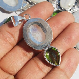 May include: Silver pendant with a round moonstone cabochon and a pear-shaped green gemstone.