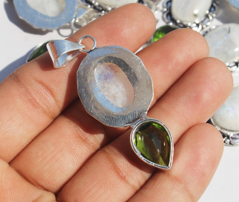 May include: Silver pendant with a round moonstone cabochon and a pear-shaped green gemstone.