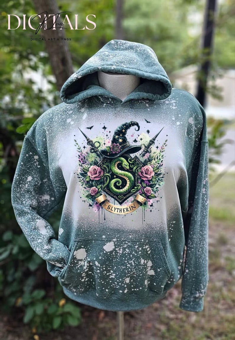 May include: A green hooded sweatshirt with a white bleach splattered design. The design features a green snake, a witch's hat, and the words "Slytherin".