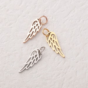 May include: Three angel wing charms in gold, silver and rose gold. The charms are made of metal and have a delicate, intricate design.