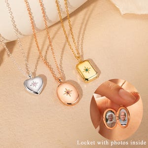 May include: Three metal necklaces with delicate chains and pendants featuring a starburst design with a small embedded stone. One pendant is heart-shaped, one is oval, and one is rectangular. An inset shows an open oval locket with two photos.