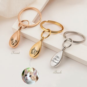 Peut inclure: Trois porte-cl&eacute;s avec des breloques en forme de larme. Les breloques sont grav&eacute;es avec le portrait d'un animal de compagnie sur le devant et les mots "Mon meilleur ami" au dos. Les porte-cl&eacute;s sont disponibles en or, argent et or rose.
