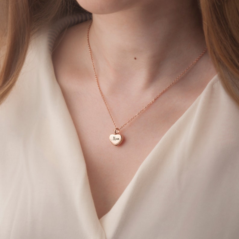 May include: A gold necklace with a heart-shaped pendant that says "Mom" on it.