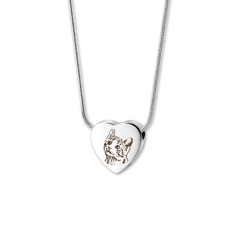 May include: A silver chain necklace with a heart-shaped pendant. The pendant features a laser-engraved image of a cat.