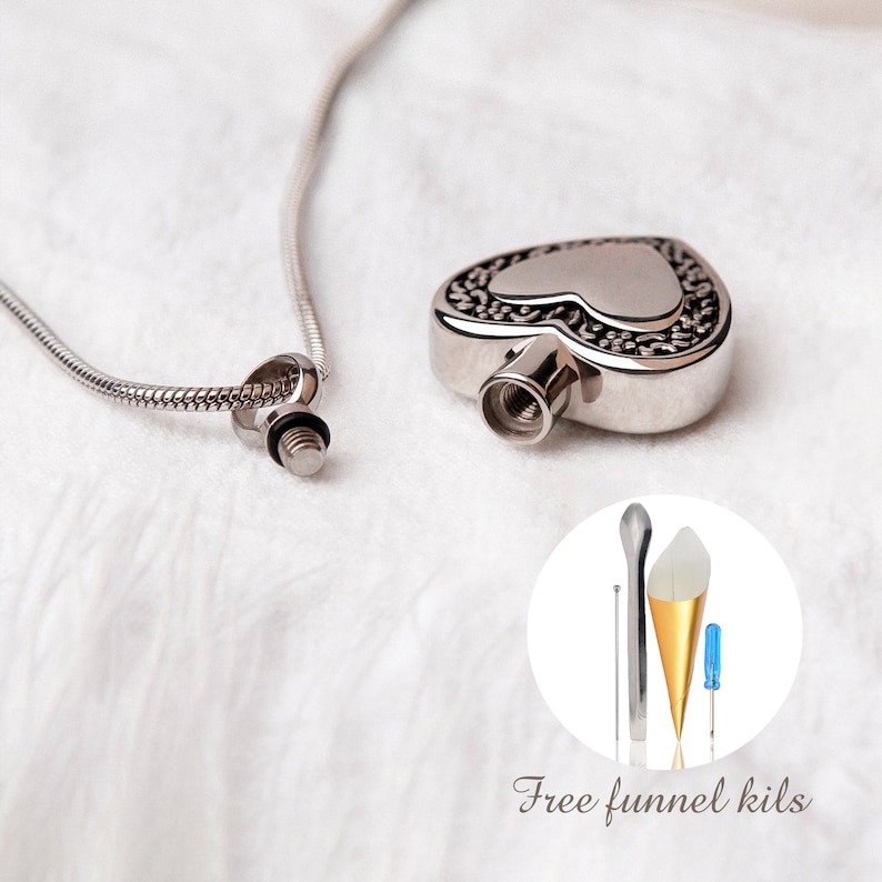 May include: Silver heart-shaped cremation necklace with a chain. The necklace comes with a small funnel and screwdriver for filling the pendant.