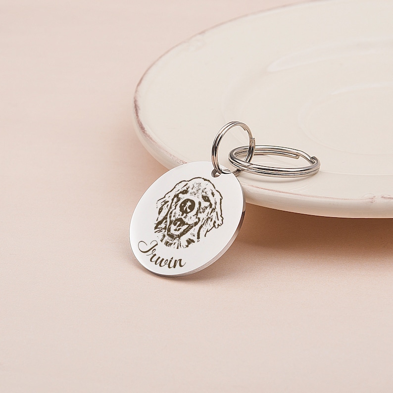 May include: Silver dog tag with a laser engraved image of a golden retriever and the name "Irwin" on a silver keyring.