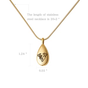 May include: Gold teardrop-shaped pendant necklace with a dog's face engraved on the front. The pendant is 1.24 inches tall and 0.55 inches wide. The necklace is 20 inches long with a 2 inch extender.