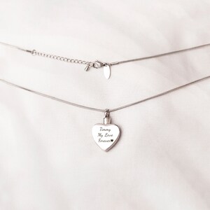 Puede incluir: Un collar de cadena de plata con un colgante en forma de coraz&oacute;n. El colgante tiene la inscripci&oacute;n "Timmy My Love Forever".