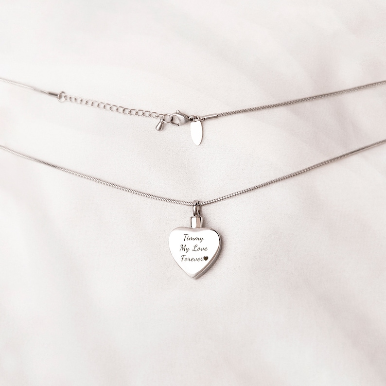 Puede incluir: Un collar de cadena de plata con un colgante en forma de coraz&oacute;n. El colgante tiene la inscripci&oacute;n "Timmy My Love Forever".