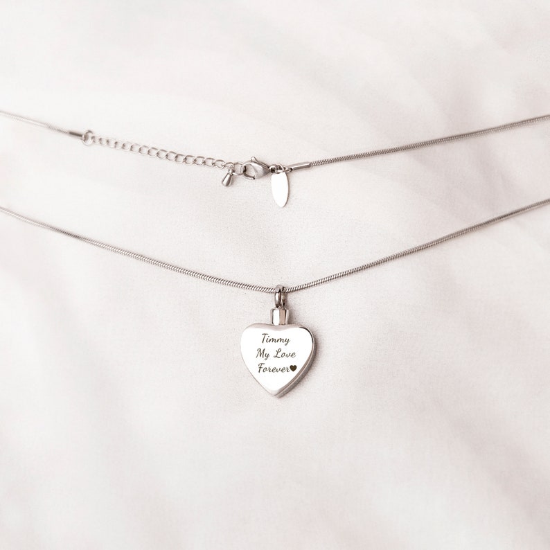 May include: A silver chain necklace with a heart-shaped pendant. The pendant has the inscription "Timmy My Love Forever" on it.